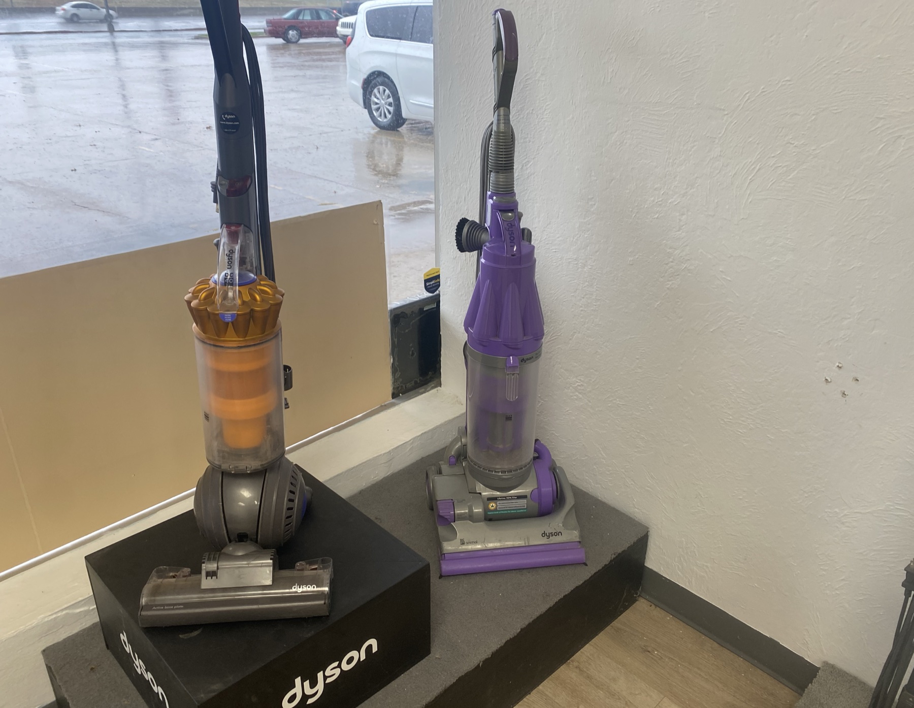 Two Dyson vacuums displayed near the Skaggs Vacuums shop window